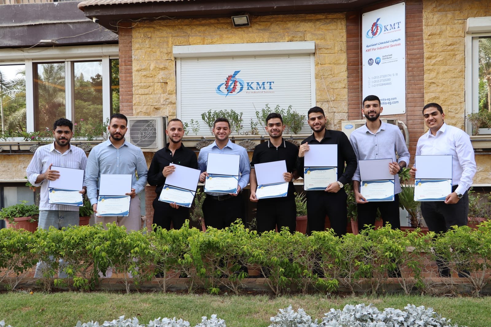Summer interns holding their completion certificates outside the KMT office